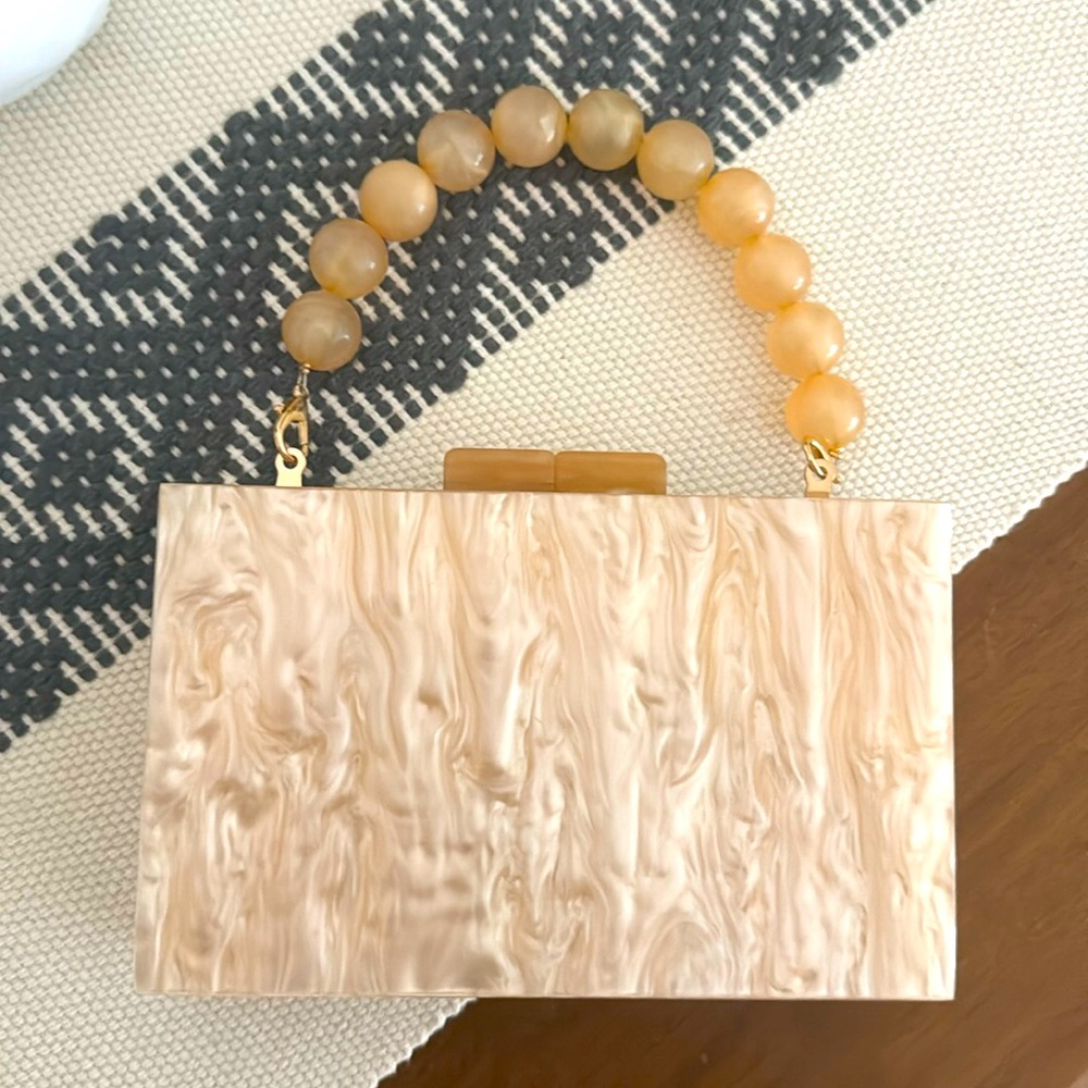 Neutral/coral marbled clutch with adjustable beaded handle or long chain strap.